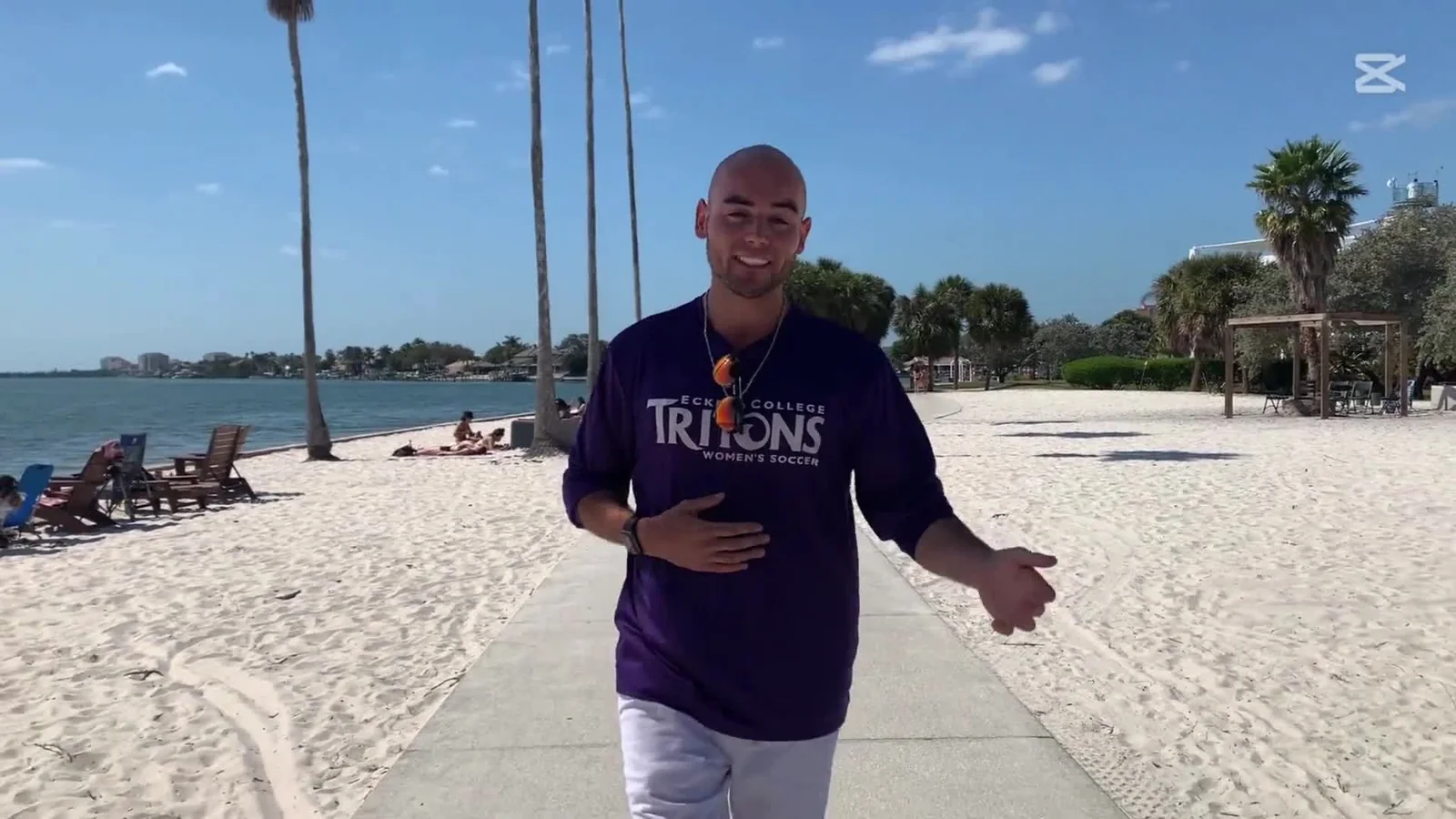 Clay on the beach at Eckerd College in a Tritons shirt.